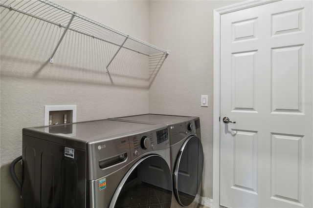 clothes washing area with tile patterned flooring and separate washer and dryer