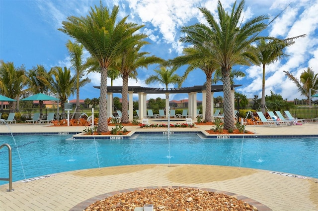 view of swimming pool with pool water feature and a patio area