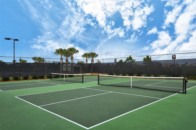 view of tennis court featuring basketball hoop