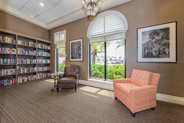 living area featuring a chandelier and carpet