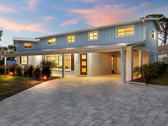 view of front of property with a carport, decorative driveway, and board and batten siding