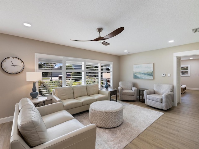 living room with light hardwood / wood-style floors and a textured ceiling