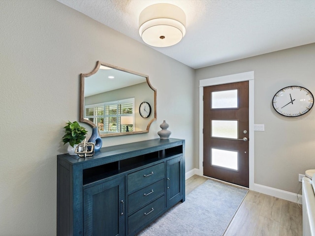 entrance foyer featuring a textured ceiling and light wood-type flooring