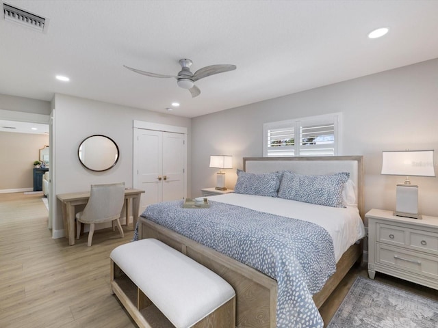 bedroom featuring ceiling fan, a closet, and light hardwood / wood-style flooring