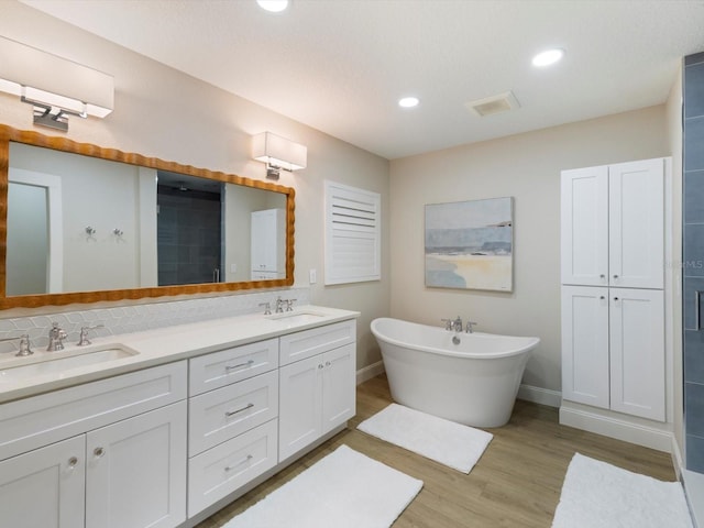 bathroom with vanity, hardwood / wood-style flooring, tasteful backsplash, and independent shower and bath