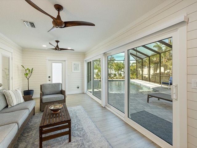 sunroom / solarium featuring ceiling fan