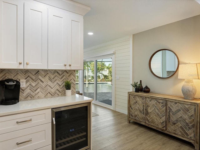 bar featuring tasteful backsplash, light hardwood / wood-style floors, white cabinetry, and beverage cooler