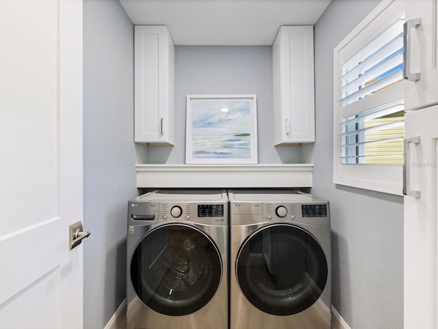 laundry room with hardwood / wood-style floors, cabinets, and washing machine and clothes dryer