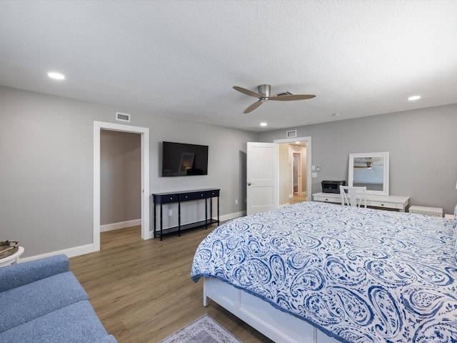 bedroom with a textured ceiling, dark hardwood / wood-style floors, and ceiling fan