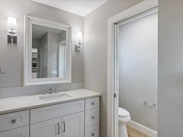 bathroom with wood-type flooring, vanity, and toilet