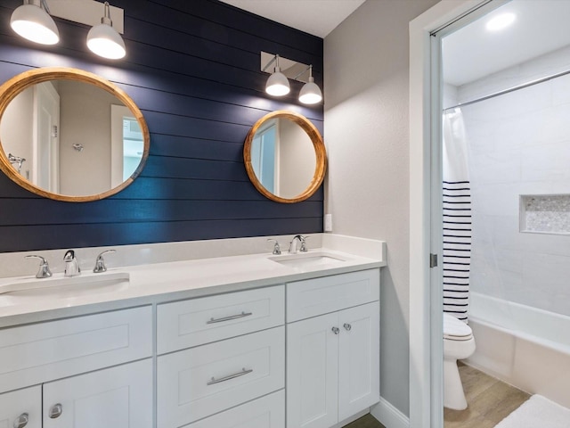 full bathroom with vanity, shower / tub combo with curtain, wood-type flooring, toilet, and wood walls