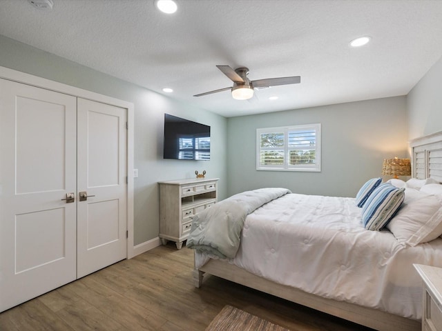 bedroom with wood-type flooring, a textured ceiling, a closet, and ceiling fan