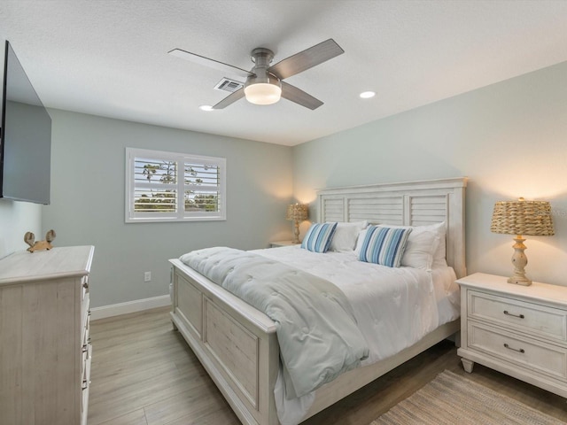 bedroom with light hardwood / wood-style flooring and ceiling fan