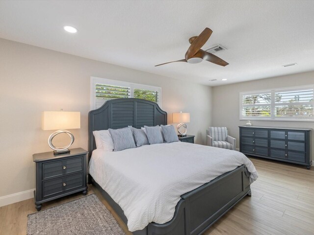 842 Nokomis Ave S, Venice, FL 34285 - bedroom with multiple windows, a ceiling fan, light wood finished floors, baseboards, and recessed lighting