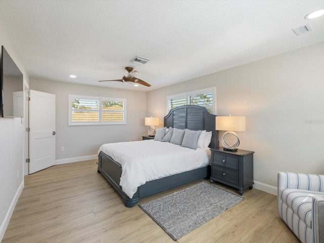 bedroom featuring multiple windows, ceiling fan, and light hardwood / wood-style flooring