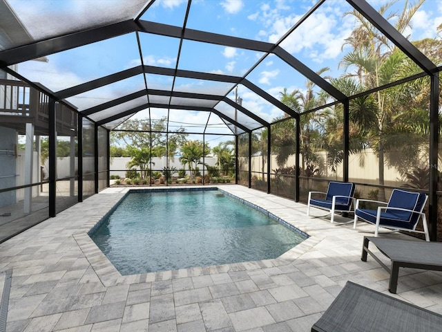 view of swimming pool with glass enclosure and a patio area