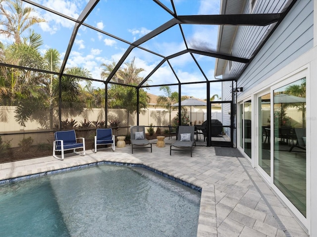 view of pool with area for grilling, a patio area, and a lanai