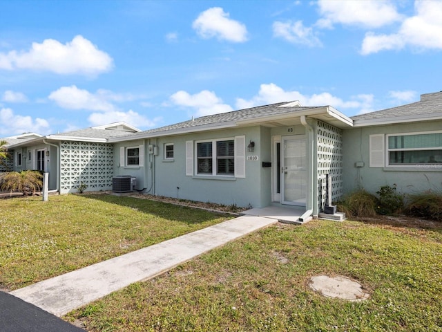 single story home featuring a front lawn and central AC unit