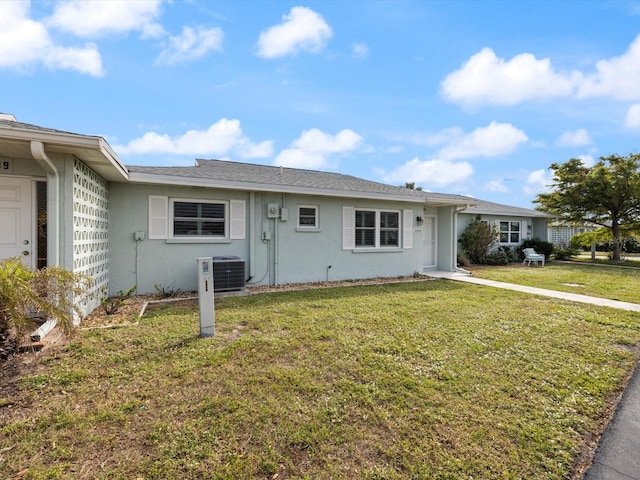 ranch-style house featuring a front yard and central AC