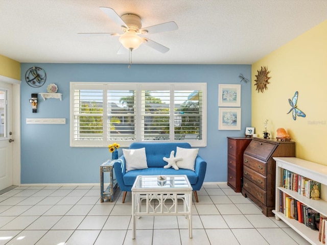 living area featuring light tile patterned floors, a textured ceiling, and ceiling fan