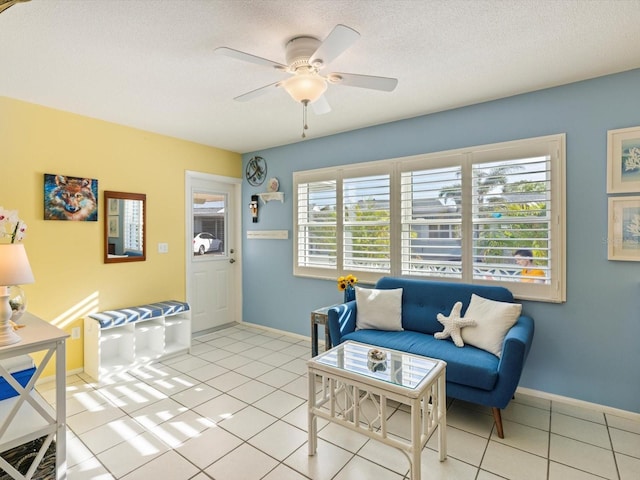 tiled living room with ceiling fan, a textured ceiling, and a wealth of natural light