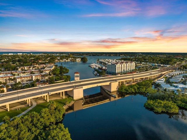 aerial view at dusk featuring a water view