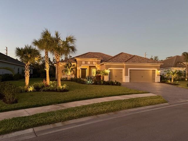 mediterranean / spanish-style home featuring a garage and a yard