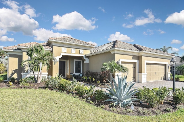 mediterranean / spanish house featuring a garage and a front yard