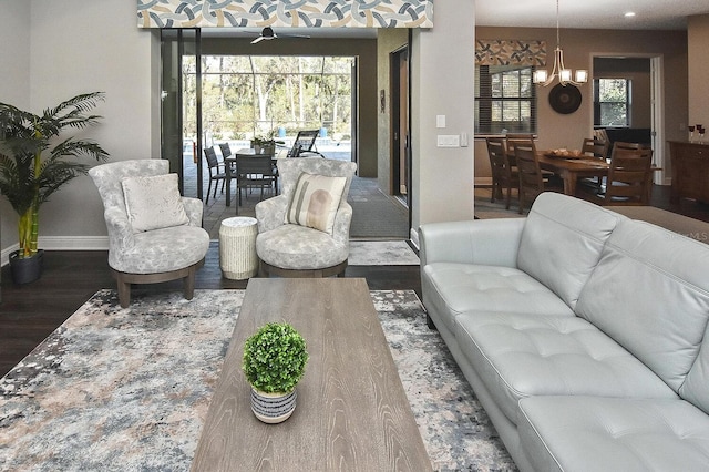 living room with dark wood-type flooring and a notable chandelier