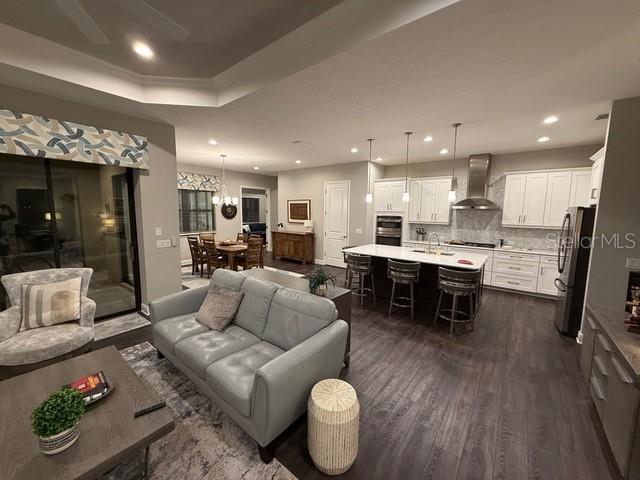 living room featuring a chandelier, dark wood-type flooring, and sink