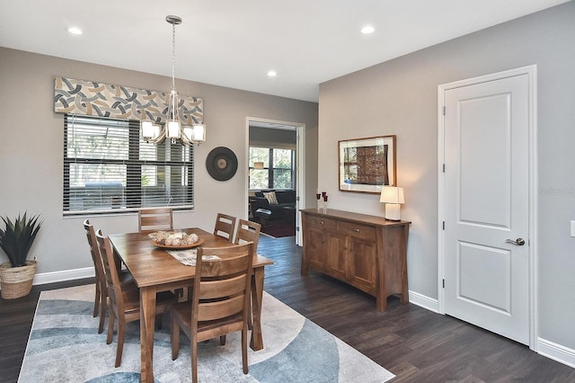 dining space featuring dark wood-type flooring and an inviting chandelier