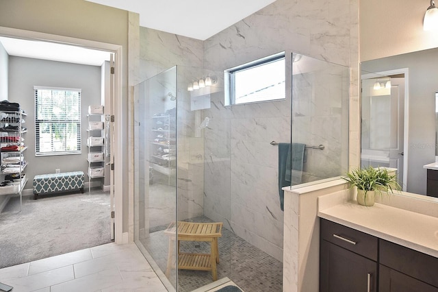 bathroom with vanity and a tile shower