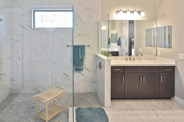 bathroom with a tile shower and vanity