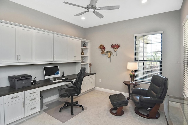 home office featuring light carpet and ceiling fan