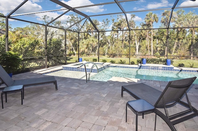 view of pool featuring an in ground hot tub, glass enclosure, and a patio area