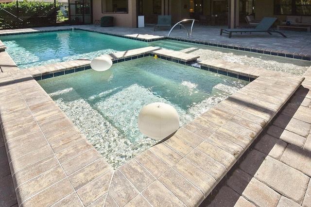 view of pool with a patio area and an in ground hot tub