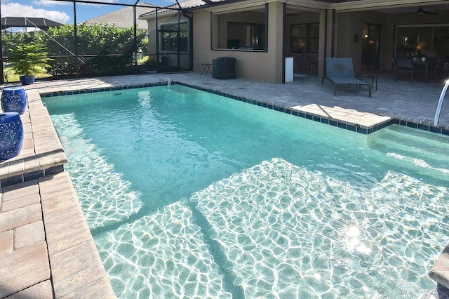 view of pool with glass enclosure and a patio