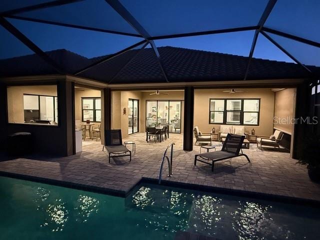 rear view of property featuring ceiling fan, a lanai, and a patio