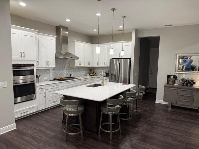 169 N Cayman Isles Blvd, Englewood, FL 34223 - kitchen with wall chimney exhaust hood, appliances with stainless steel finishes, a sink, light countertops, and a breakfast bar