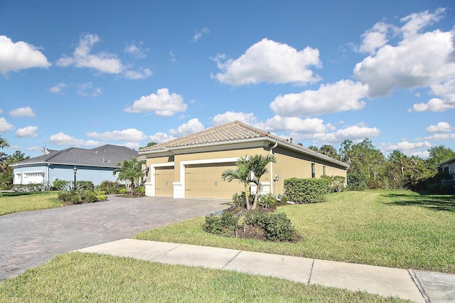 169 N Cayman Isles Blvd, Englewood, FL 34223 - view of front of home featuring stucco siding, a front lawn, decorative driveway, a tile roof, and an attached garage