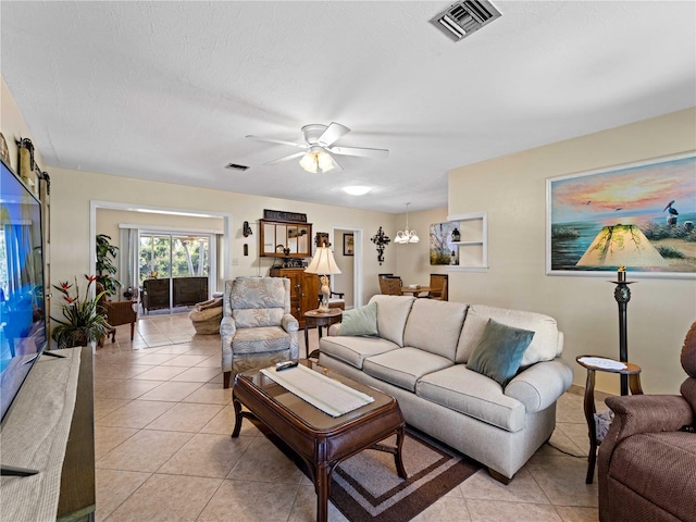 tiled living room featuring a textured ceiling and ceiling fan