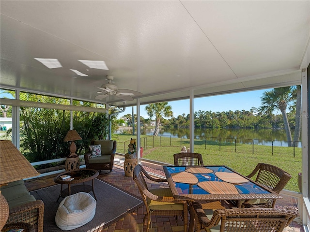 sunroom with a water view and ceiling fan