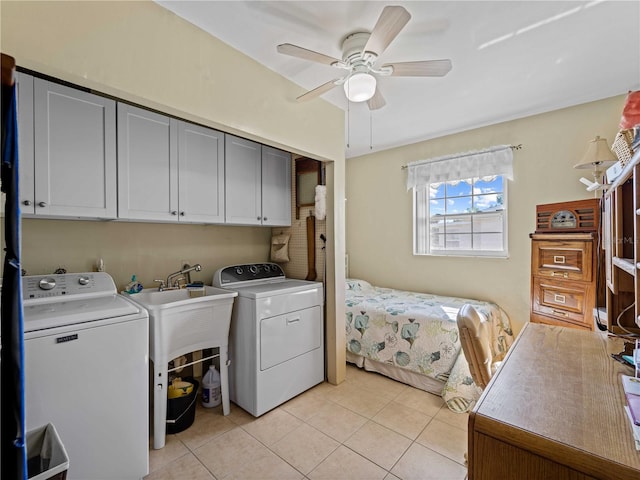 laundry room with cabinets, washing machine and clothes dryer, ceiling fan, and light tile patterned flooring