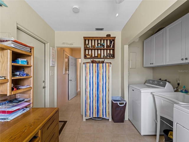 washroom with cabinets, light tile patterned flooring, and washer / dryer