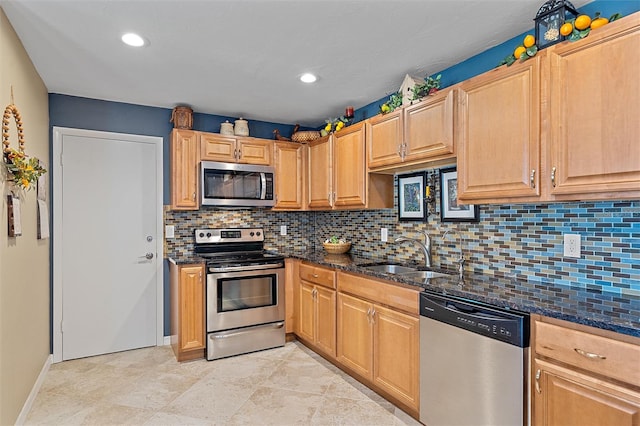 kitchen featuring stainless steel appliances, tasteful backsplash, dark stone counters, and sink