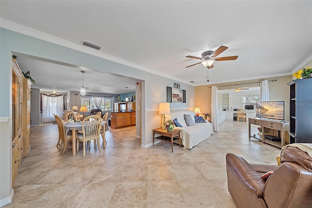 living room featuring ceiling fan and crown molding