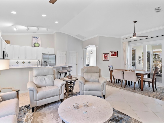 tiled living room featuring crown molding, sink, ceiling fan, and lofted ceiling