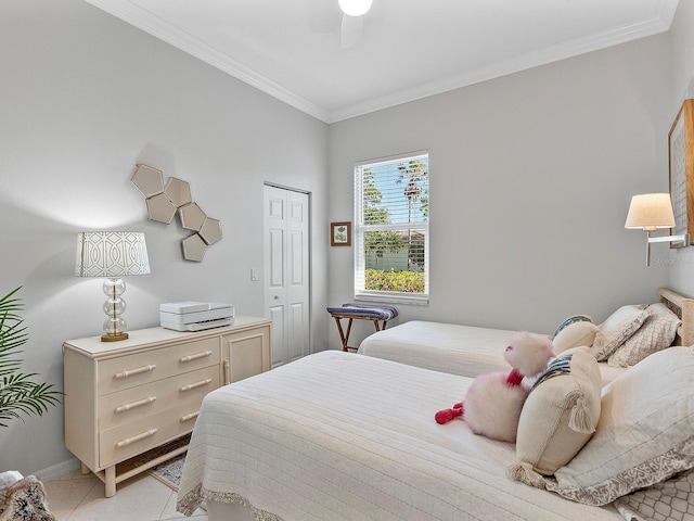 bedroom with light tile patterned floors, a closet, ornamental molding, and ceiling fan