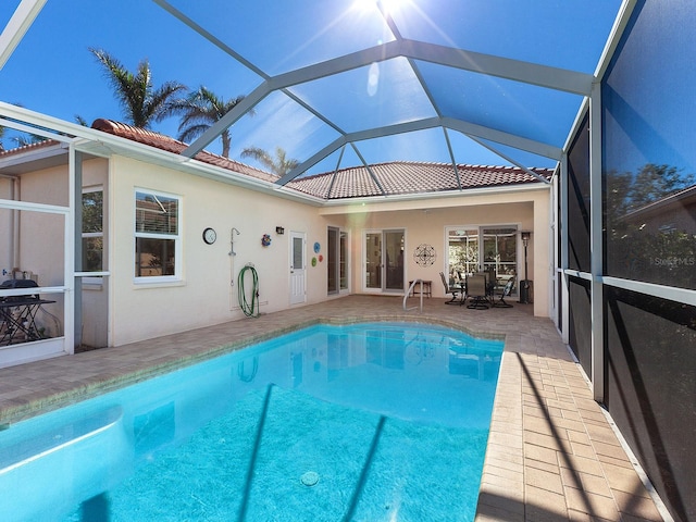 view of swimming pool with glass enclosure, a patio area, and french doors