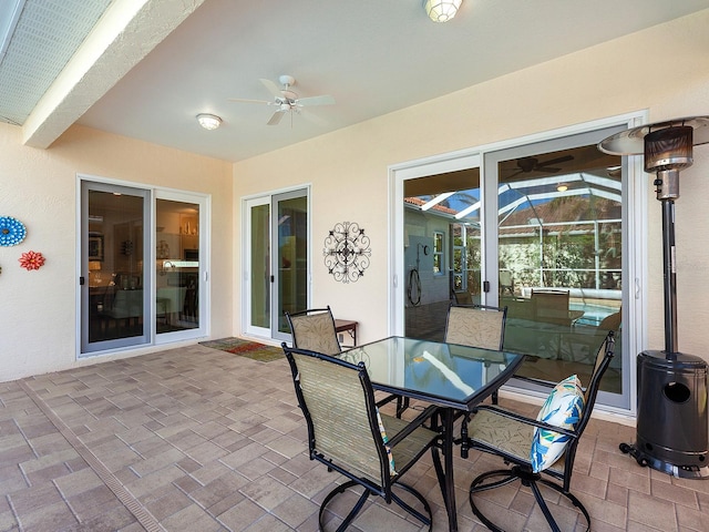 view of patio featuring glass enclosure and ceiling fan